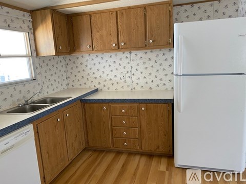 A kitchen with wooden cabinets and a white refrigerator.