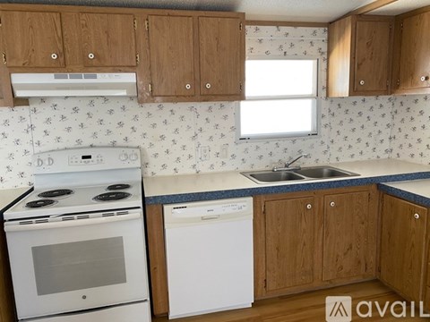A kitchen with wooden cabinets and a white stove top oven.