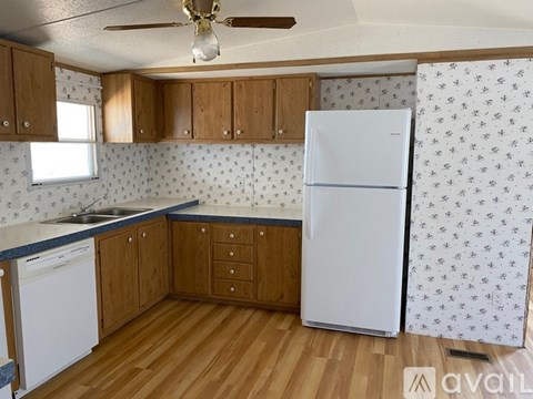 A kitchen with wooden cabinets and a white fridge.
