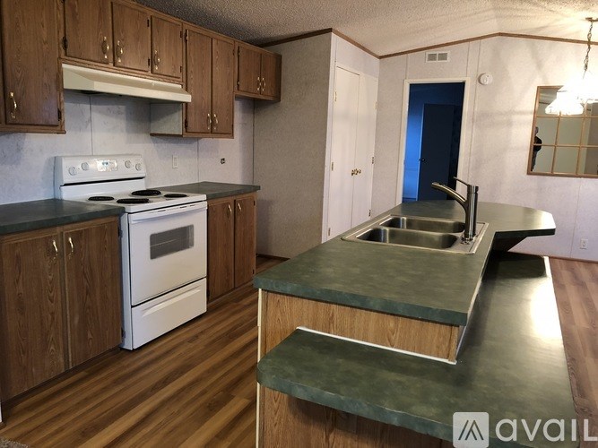 A kitchen with a white stove and wooden cabinets.