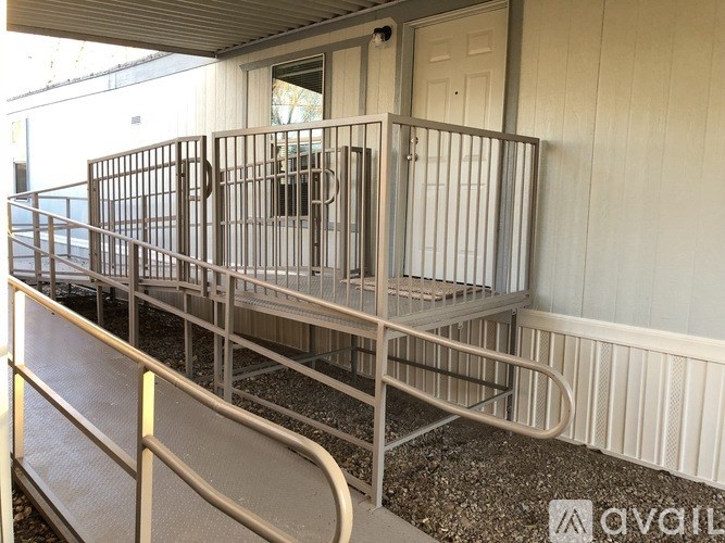 A metal gate is in front of a white door.