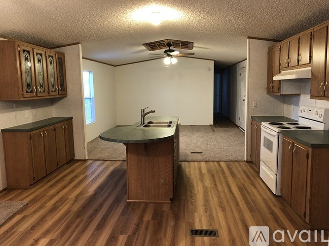 A kitchen with wooden floors and a central island.