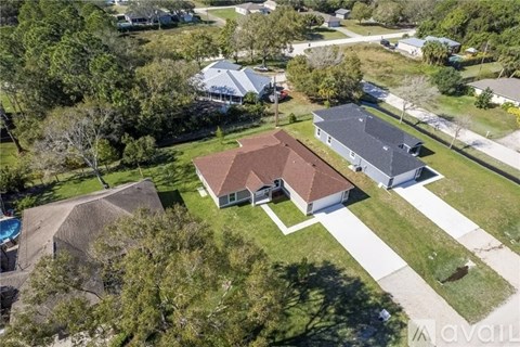 A bird's eye view of a residential area with houses and a swimming pool.