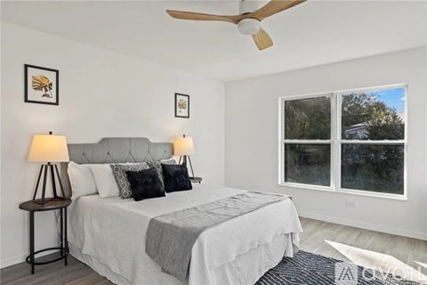 A bedroom with a large bed and a ceiling fan.