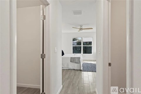 A bedroom with a bed and a ceiling fan.