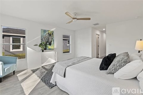 A bedroom with a large bed and a ceiling fan.