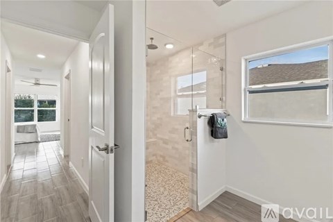 A bathroom with a walk-in shower and a window.