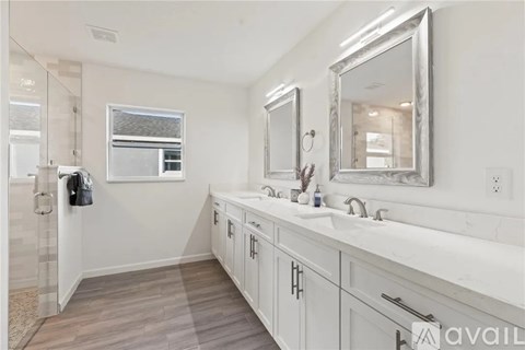 A bathroom with a large mirror and a window.
