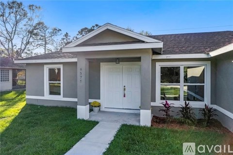 A house with a white door and windows is for sale.