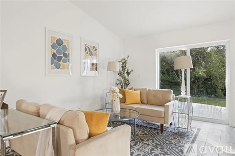 A living room with a glass table and a sofa.