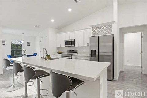 A modern kitchen with a white island and stainless steel appliances.