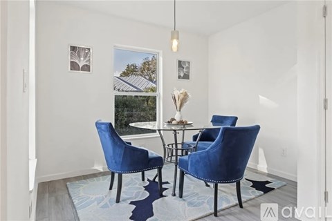 A living room with a glass table and blue chairs.