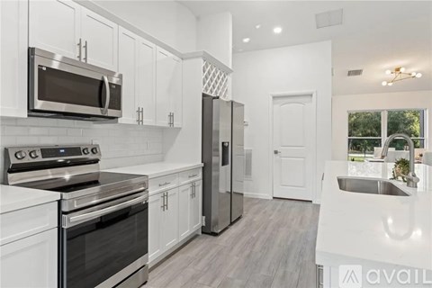 A modern kitchen with stainless steel appliances and white cabinets.