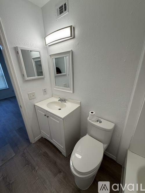 A white toilet and sink in a small bathroom.