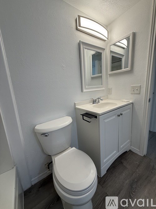 A white toilet sits next to a sink in a bathroom.