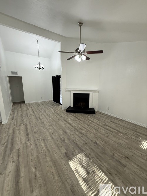 A room with a fireplace and a ceiling fan.