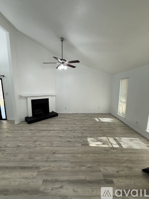 A room with a fireplace and a ceiling fan.