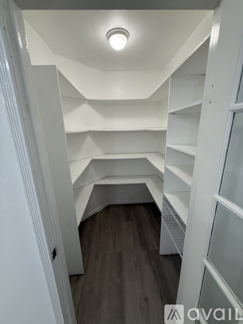 A white interior with a wooden floor and a white ceiling.