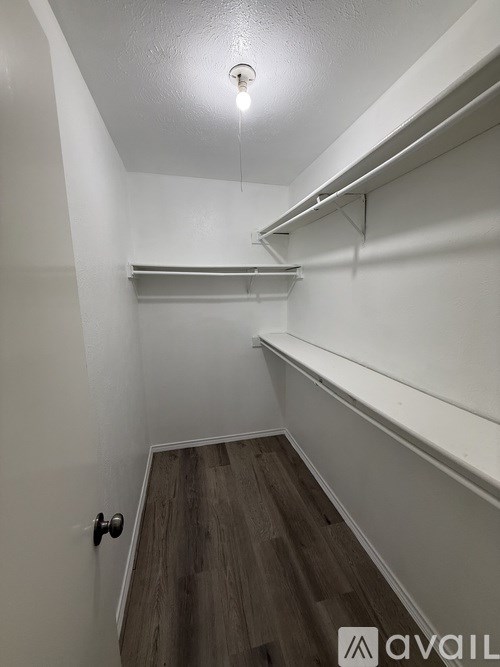 A hallway with a light on and a door at the end.