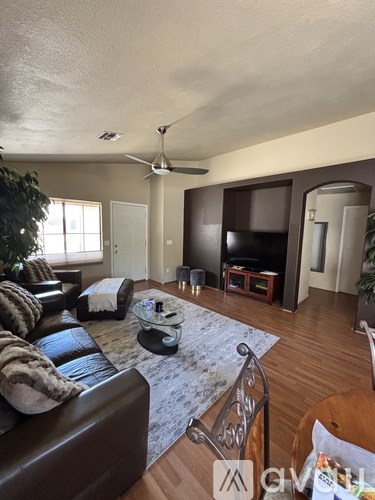 A living room with a brown leather couch and a glass coffee table.