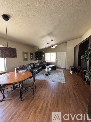 A living room with a couch, coffee table, and a ceiling fan.