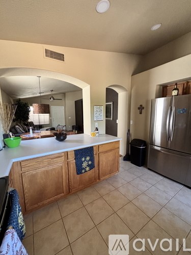 A kitchen with wooden cabinets and a stainless steel refrigerator.