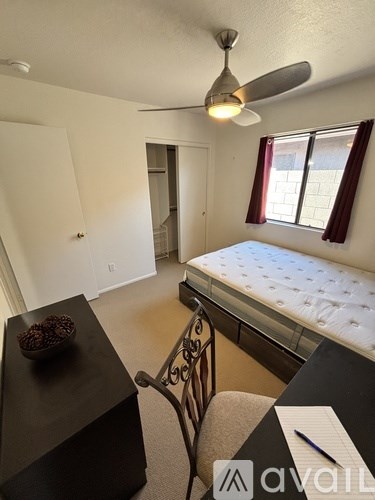 A bedroom with a bed, desk, and chair.