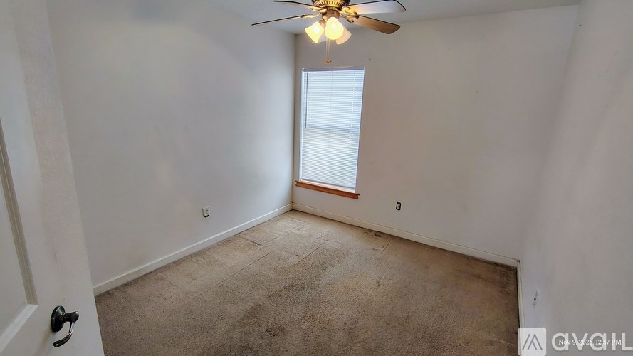 A room with a ceiling fan and a window.