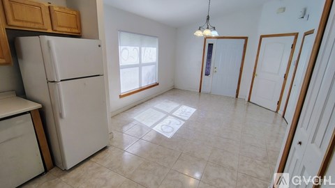 A kitchen with a white refrigerator and wooden cabinets.