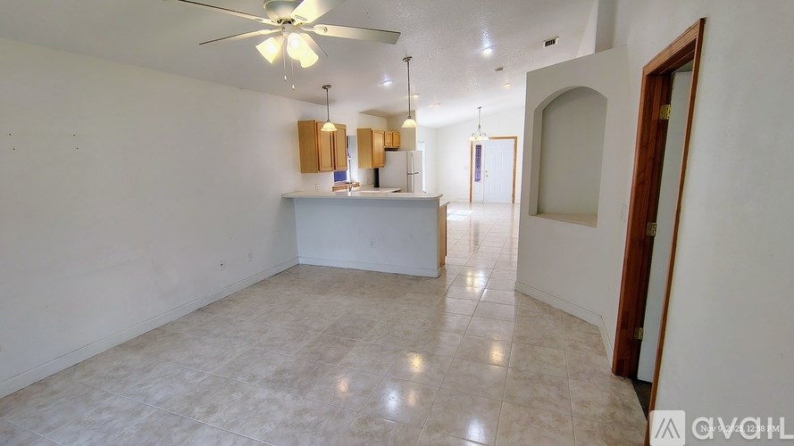 A spacious room with a ceiling fan and a white counter.