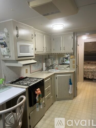 A kitchen with white cabinets and appliances.