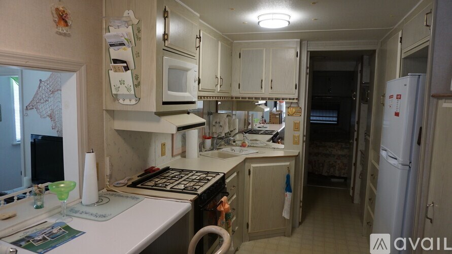 A kitchen with white cabinets and a white fridge.