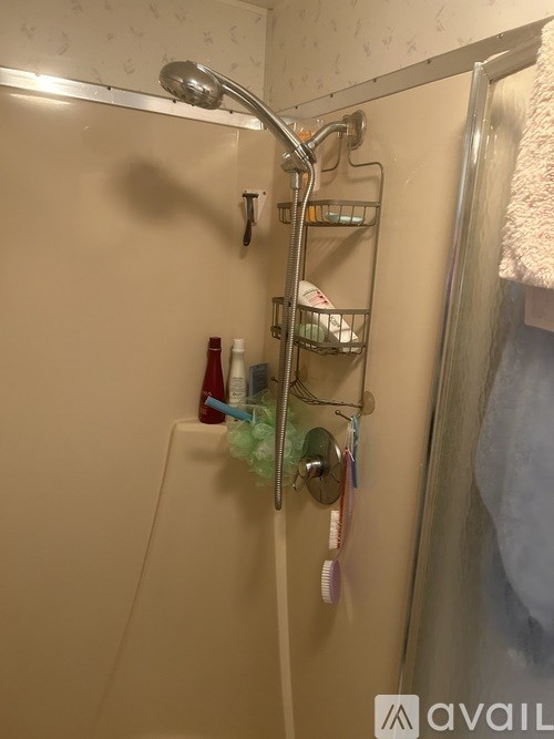 A shower with a rack and a shower head.