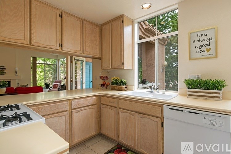A kitchen with wooden cabinets and a framed picture on the wall.