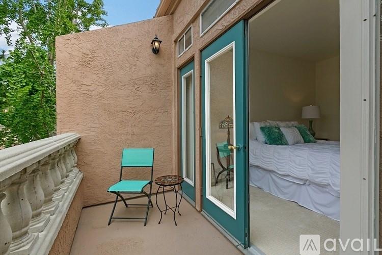 A balcony with a chair and table.