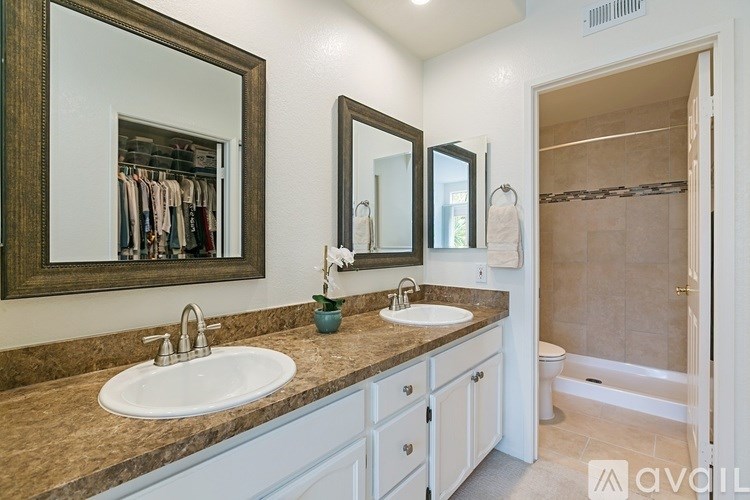 A bathroom with two sinks and a large mirror.