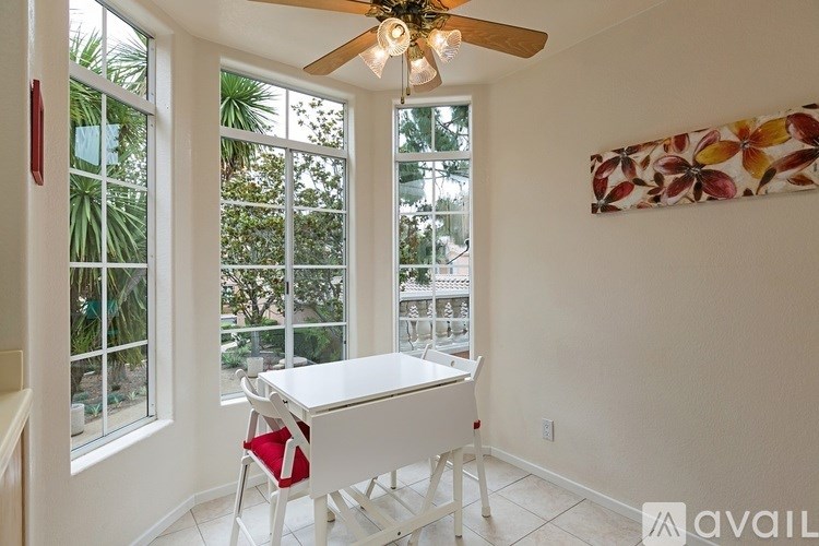 A room with a table and chairs and a ceiling fan.