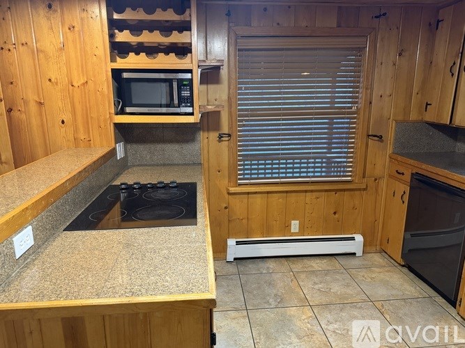A kitchen with wooden cabinets and a stove top oven.