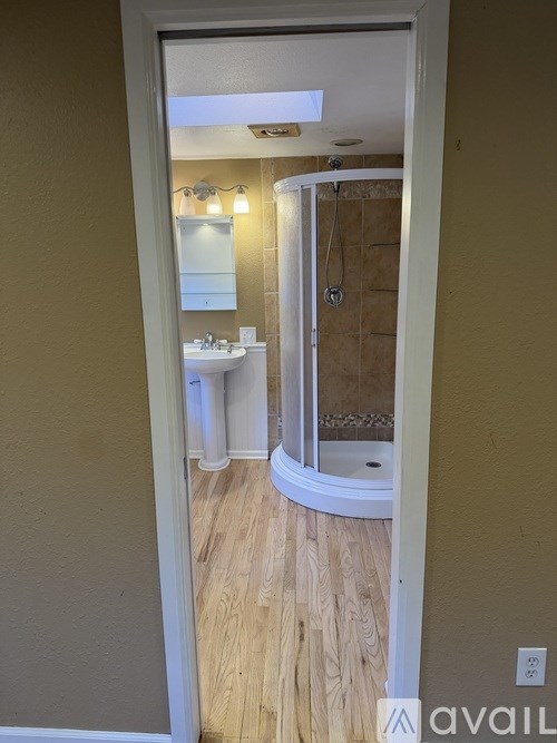 A bathroom with a sink, mirror, and shower.