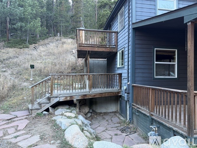 A house with a balcony and a stone pathway leading to it.