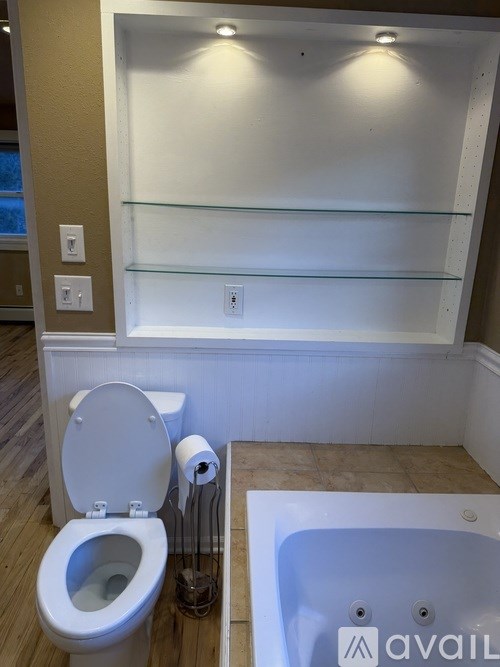A white toilet sits next to a bathtub in a bathroom.