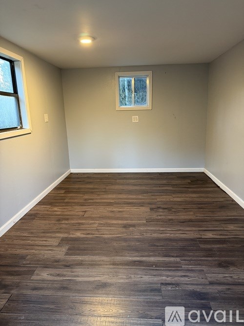 A room with wooden flooring and a window.