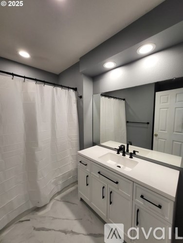 A bathroom with a white sink and cabinets.