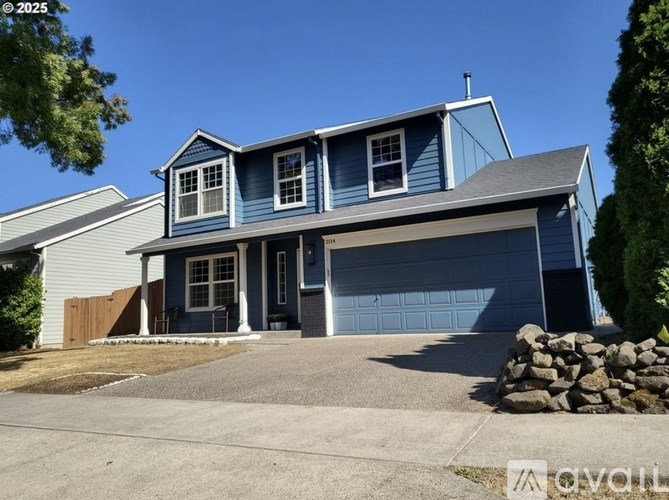 A blue house with a grey garage door and a grey roof.