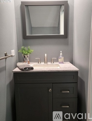 A bathroom with a sink, mirror, and cabinet.