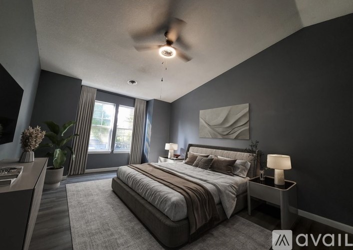 A modern bedroom with a large bed and a ceiling fan.