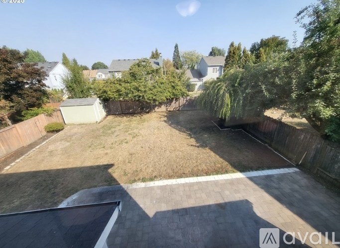 A backyard with a fence and a shed.