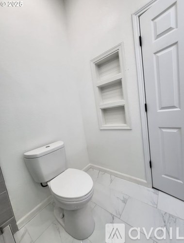 A white toilet in a bathroom with a white door.