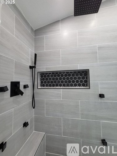 A modern bathroom with a walk-in shower and a bench.