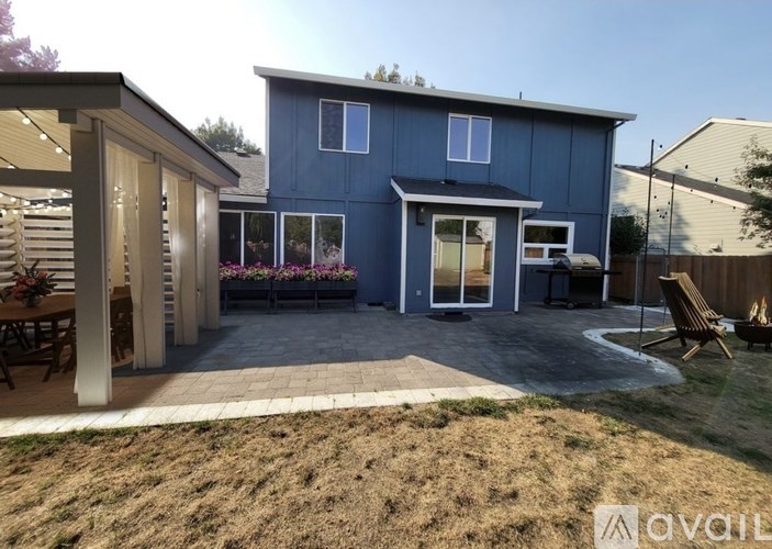 A blue house with a patio and a fire pit.